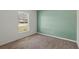 A carpeted bedroom is painted green and has a window that provides natural light and a neutral interior at 11987 Se 95Th Ter, Belleview, FL 34420