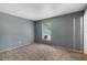 A carpeted bedroom is painted gray and has a window that provides natural light and a neutral interior at 11987 Se 95Th Ter, Belleview, FL 34420