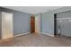 A carpeted bedroom is painted gray and has a doorway to the left and a closet to the right at 11987 Se 95Th Ter, Belleview, FL 34420
