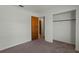 Bedroom with door, closet, neutral walls, carpet, and natural light, providing a comfortable space at 11987 Se 95Th Ter, Belleview, FL 34420