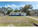 Charming single-story home with two-tone paint, a well-manicured lawn, and mature trees at 11987 Se 95Th Ter, Belleview, FL 34420
