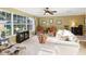 Bright living room with large windows, neutral carpet, ceiling fan, and comfortable seating at 1202 Bly Ct, Eustis, FL 32726