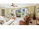 Bright living room with large windows, neutral carpet, ceiling fan, and comfortable seating at 1202 Bly Ct, Eustis, FL 32726