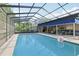 Enclosed pool with screened-in enclosure and a bright blue awning at 1202 Bly Ct, Eustis, FL 32726