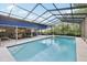 Enclosed pool with screened-in enclosure, patio area, and a bright blue awning at 1202 Bly Ct, Eustis, FL 32726