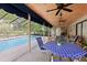 Covered and screened pool patio with wood ceiling, ceiling fans, and an outdoor dining area at 1202 Bly Ct, Eustis, FL 32726