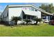 Charming single-story home with a well-maintained lawn and awning with covered parking on a sunny day at 121 Maple Dr, Debary, FL 32713