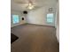 Spacious living room featuring neutral carpet, natural light, and a modern light fixture at 121 Maple Dr, Debary, FL 32713