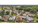 An aerial view displays community streets, well-maintained lawns, and mature trees at 1210 Weaton Ct, The Villages, FL 32162