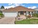 Charming home with a brick driveway, well-manicured lawn, and a welcoming front entrance at 1210 Weaton Ct, The Villages, FL 32162