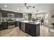 Modern kitchen boasts dark cabinetry, stainless steel appliances, and a central island at 1210 Weaton Ct, The Villages, FL 32162