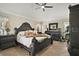 Spacious main bedroom featuring a ceiling fan, wood floors, and dark wood furniture at 1210 Weaton Ct, The Villages, FL 32162