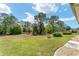 Expansive backyard with lush green grass, mature trees, and meticulously maintained landscaping at 12511 Se 91St Terrace Rd, Summerfield, FL 34491