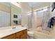 Bathroom featuring wood cabinets, neutral countertops, and shower over tub at 12511 Se 91St Terrace Rd, Summerfield, FL 34491