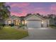Charming single Gathering home with a well manicured lawn and a beautiful sunset in the background at 12511 Se 91St Terrace Rd, Summerfield, FL 34491
