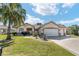 Inviting home with a well-manicured lawn, mature trees, and an extra wide driveway at 12511 Se 91St Terrace Rd, Summerfield, FL 34491