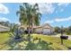 Charming home with a lush front yard featuring a palm tree and well-manicured landscaping at 12511 Se 91St Terrace Rd, Summerfield, FL 34491