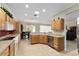 Open kitchen with wood cabinets, stainless steel appliances, and breakfast bar seating at 12511 Se 91St Terrace Rd, Summerfield, FL 34491