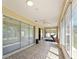 Enclosed lanai area with tiled floors, ceiling fan, sliding glass doors, and workout equipment at 12511 Se 91St Terrace Rd, Summerfield, FL 34491