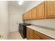 Functional laundry room with cabinets, counter, modern washer, and dryer at 12511 Se 91St Terrace Rd, Summerfield, FL 34491