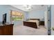 Bright main bedroom features a ceiling fan, neutral carpet, and large window views at 12511 Se 91St Terrace Rd, Summerfield, FL 34491