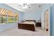 Bright main bedroom features a ceiling fan, neutral carpet, and views to the ensuite bathroom at 12511 Se 91St Terrace Rd, Summerfield, FL 34491