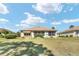 Back of house with sunroom and small landscaped yard, nice grass and manicured shrubs at 12511 Se 91St Terrace Rd, Summerfield, FL 34491