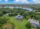 Expansive aerial view showcasing a home surrounded by mature trees, a lake, and neighborhood homes at 13112 Luntz Point Ln, Windermere, FL 34786