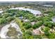 An aerial view showcasing the neighborhood featuring beautiful homes, lush trees, and sparkling lakes at 13112 Luntz Point Ln, Windermere, FL 34786