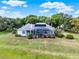 An aerial view of a house highlighting the expansive screened-in pool, patio, and well-manicured lawn at 13112 Luntz Point Ln, Windermere, FL 34786