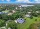 Wide aerial shot showcasing the home, manicured lawn, mature trees, and serene lake at 13112 Luntz Point Ln, Windermere, FL 34786