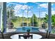 Covered backyard pool and spa with lush greenery beyond, viewed from inside the home at 13112 Luntz Point Ln, Windermere, FL 34786