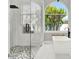 Bright bathroom features a glass-enclosed shower and modern soaking tub beneath a large arched window at 13112 Luntz Point Ln, Windermere, FL 34786