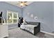 Cozy bedroom featuring soft blue walls, plush gray carpet, and a comfortable daybed by a sunny window at 13112 Luntz Point Ln, Windermere, FL 34786