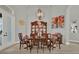Formal dining room with a round wood table set, decorative china cabinet, art pieces, and natural light at 13112 Luntz Point Ln, Windermere, FL 34786