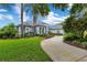 Well-maintained single-story home with a lush green lawn and a curved driveway lined with mature trees at 13112 Luntz Point Ln, Windermere, FL 34786