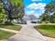 Side exterior featuring a three-car garage, landscaping, and circular driveway at 13112 Luntz Point Ln, Windermere, FL 34786
