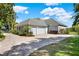 View of the side exterior with a three-car garage and circular driveway at 13112 Luntz Point Ln, Windermere, FL 34786