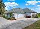 Exterior showcasing a three-car garage, landscaping, and driveway at 13112 Luntz Point Ln, Windermere, FL 34786