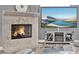 Close-up of a stone fireplace with a burning fire, accompanied by a television and modern décor at 13112 Luntz Point Ln, Windermere, FL 34786