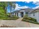 Beautiful single-story home with a well-manicured lawn and a grand front entrance with decorative palm trees at 13112 Luntz Point Ln, Windermere, FL 34786
