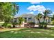 Beautifully landscaped front yard with lush green lawn and mature palm trees leading to the house at 13112 Luntz Point Ln, Windermere, FL 34786
