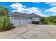 Exterior shot showcasing a three-car garage with matching siding and well-kept driveway at 13112 Luntz Point Ln, Windermere, FL 34786