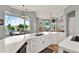 Modern kitchen featuring a large island, white cabinetry, quartz countertops, and views of the pool at 13112 Luntz Point Ln, Windermere, FL 34786