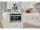 Modern kitchen with white cabinets, stainless steel appliances, and center island with built-in microwave at 13112 Luntz Point Ln, Windermere, FL 34786