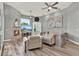 Bright living room with stone fireplace, large windows, ceiling fans, and comfortable seating area at 13112 Luntz Point Ln, Windermere, FL 34786