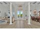 Open concept living room with high ceilings, columns, wood-look floors, and view of backyard pool at 13112 Luntz Point Ln, Windermere, FL 34786