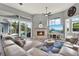 Spacious living room featuring a stone fireplace, large windows with backyard views, ceiling fans, and ample seating at 13112 Luntz Point Ln, Windermere, FL 34786