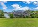 Back of the home featuring a large screened-in lanai and lush green lawn at 13112 Luntz Point Ln, Windermere, FL 34786