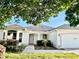 Charming single-story home with a well-maintained lawn, pink accents, and lush landscaping at 1312 Corona Ave, The Villages, FL 32159